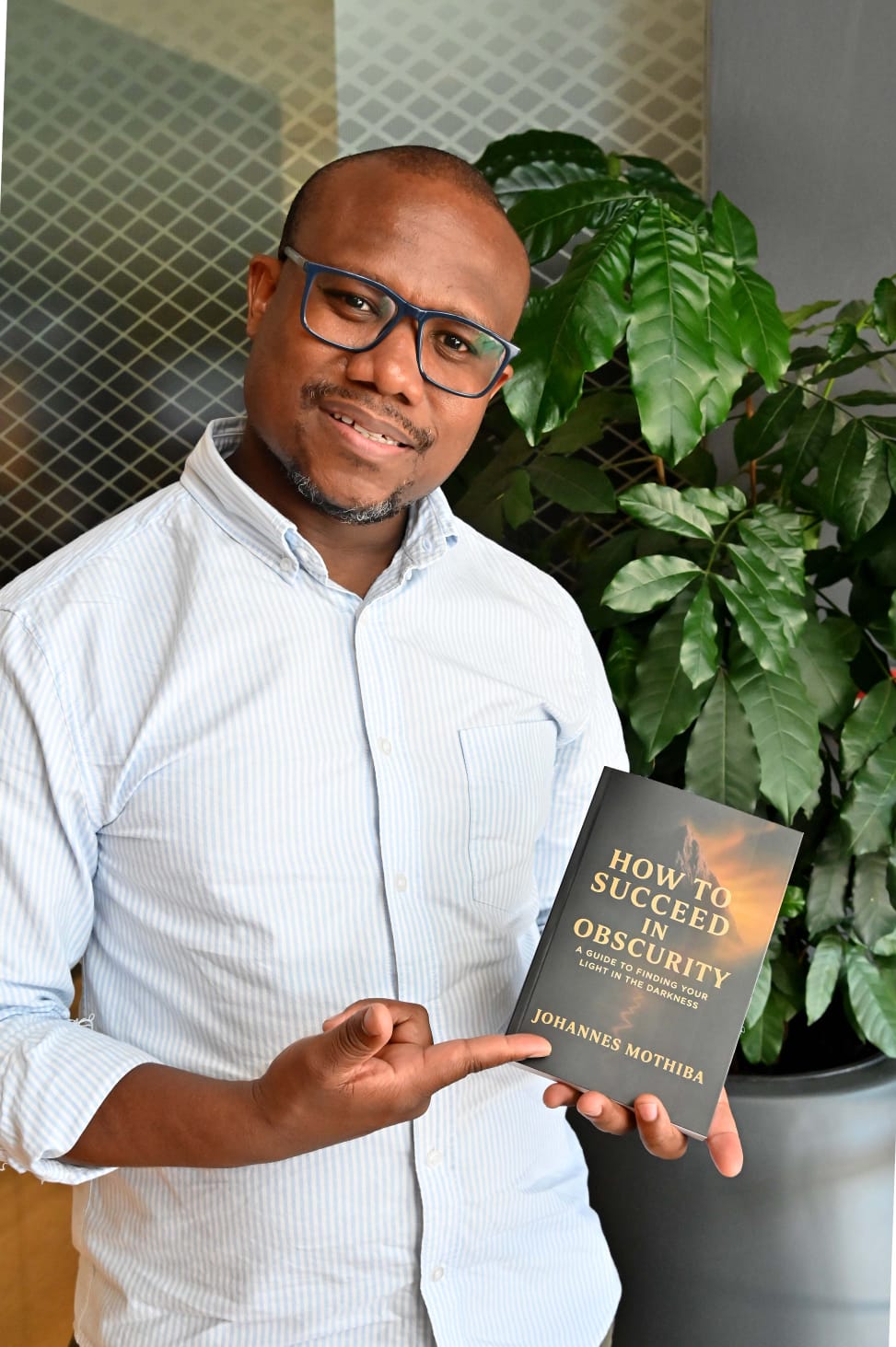 Johannes Mothiba holding his book